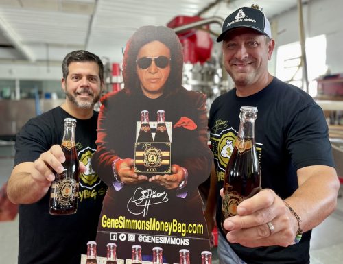 Rock Steady Sodas CFO Chris Haick and Vice President John Janik proudly display their MoneyBag Sodas partnership with Gene Simmons, who is shown in replica form.